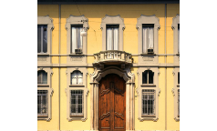 Ingresso d'Onore | L'ingresso del Palazzo su Corso Monforte assunse l'aspetto attuale nei decenni finali dell'Ottocento, sotto la proprietà Isimbardi: quando furono abbattuti i bastioni, i cosiddetti "Corpi santi" -la cintura suburbana cresciuta al di fuori- ebbero una piena espansione, e la città assunse un nuovo assetto viario adatto al traffico di carrozze. La via Monforte, non più borgo, non ancora Corso, assunse il rango di importante via di passaggio, e la facciata fu adeguata di conseguenza nel 1888 a cura dell'Architetto Emilio Alemagna.